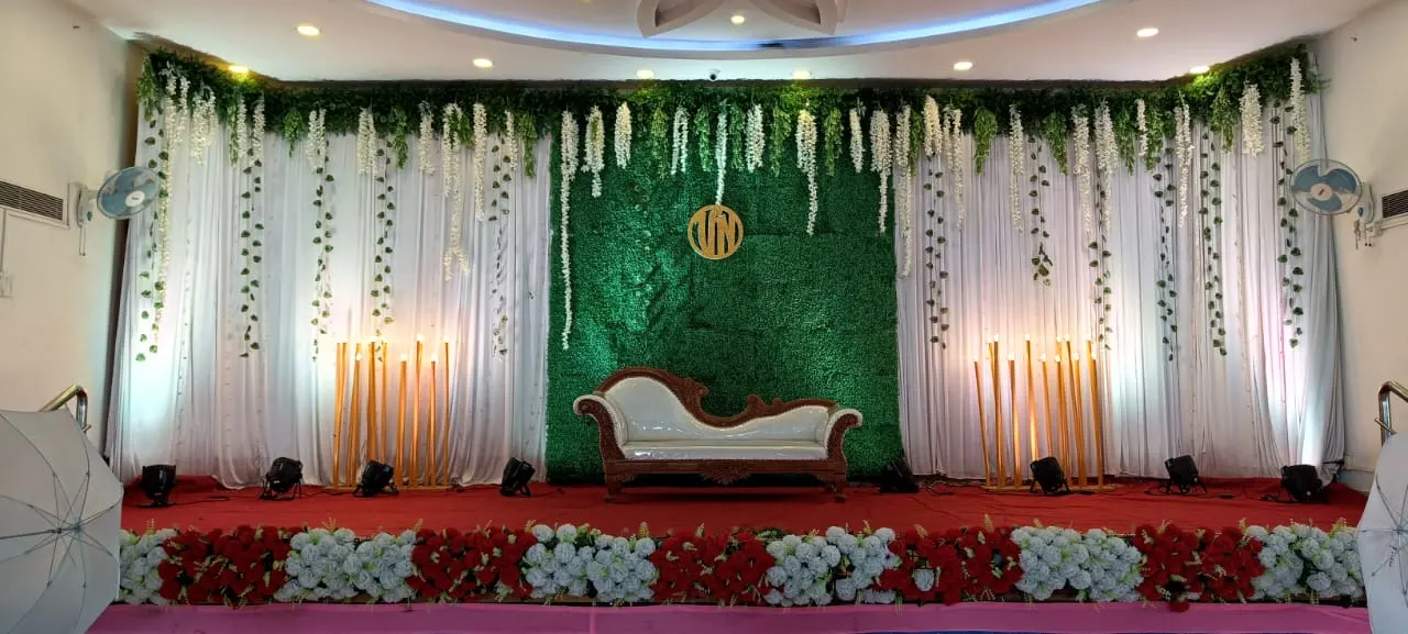 Stage with a green leaf wall and white flowers
