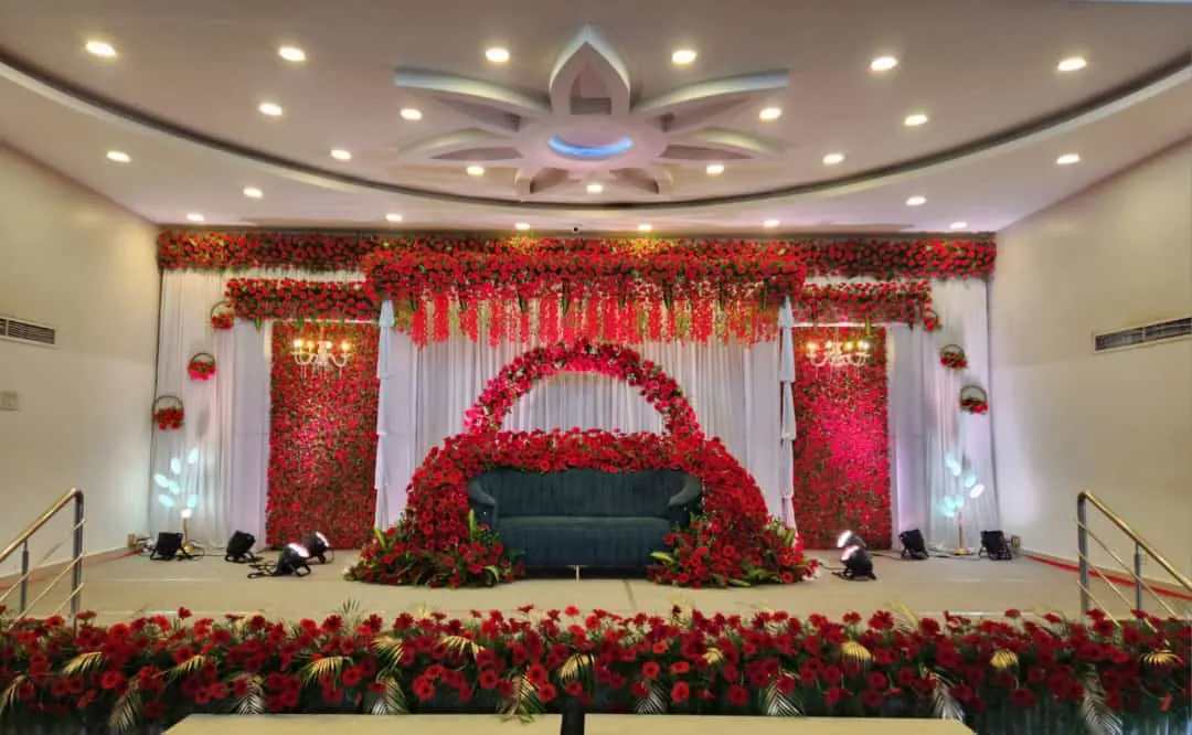 Wedding stage framed in red roses with a heart arch