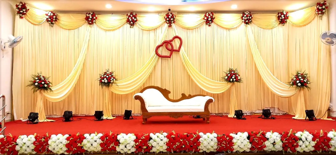 Wedding stage with cream drapes and red carpet